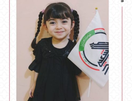 تشعر طفلة صغيرة بالأمن والسرور مع علم الحشد الشعبي